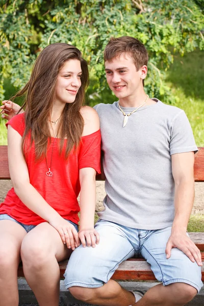 Jeune couple adolescent sur un banc Photo De Stock