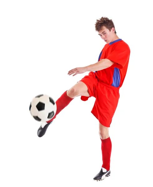 Fotbollspelare som skjuter en boll Royaltyfria Stockfoton
