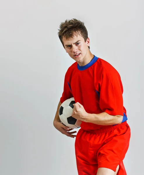 Joven futbolista sosteniendo una pelota — Foto de Stock