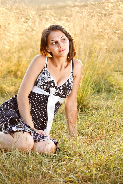 Kobieta siedząca na trawie — Zdjęcie stockowe