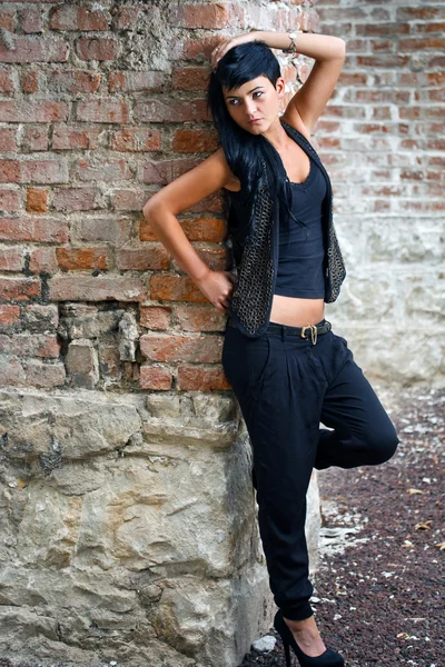 Young woman near brick wall — Stock Photo, Image