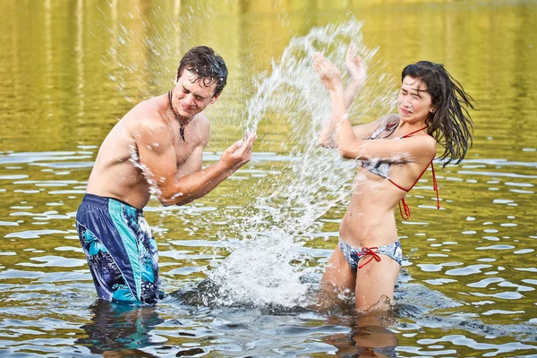 Casal brincando na água — Fotografia de Stock