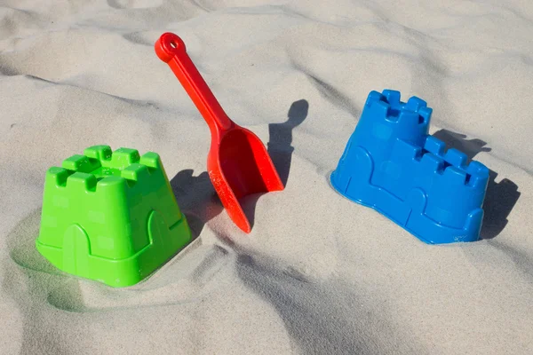 Песчаный замок и лопата на пляже — стоковое фото