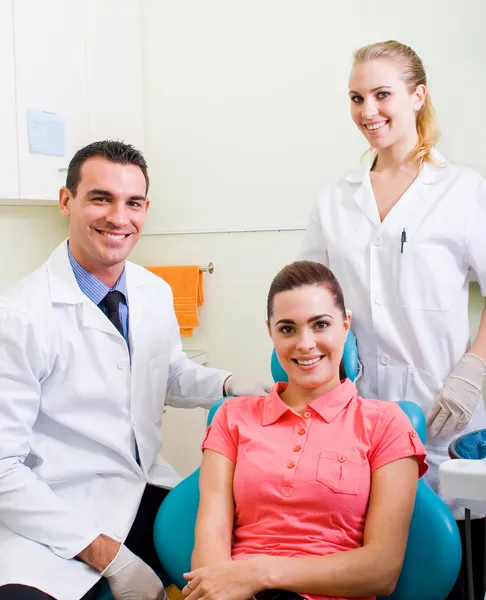 Улыбающийся стоматолог, ассистент и пациент — стоковое фото