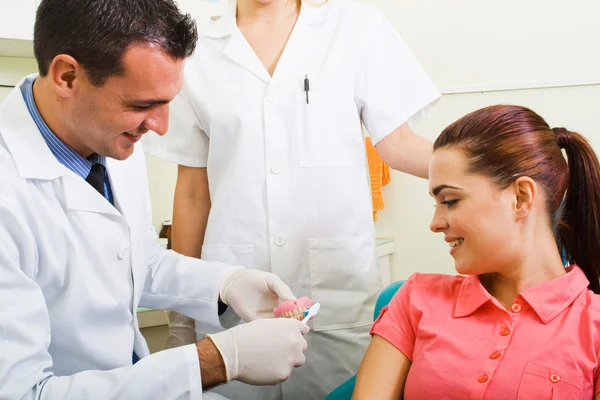 Стоматолог демонстрирует зубную щетку — стоковое фото