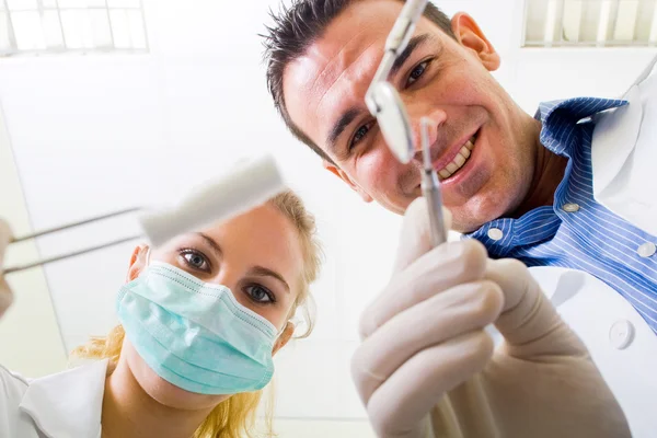 Dentist and assistant working on patient — Stock Photo, Image