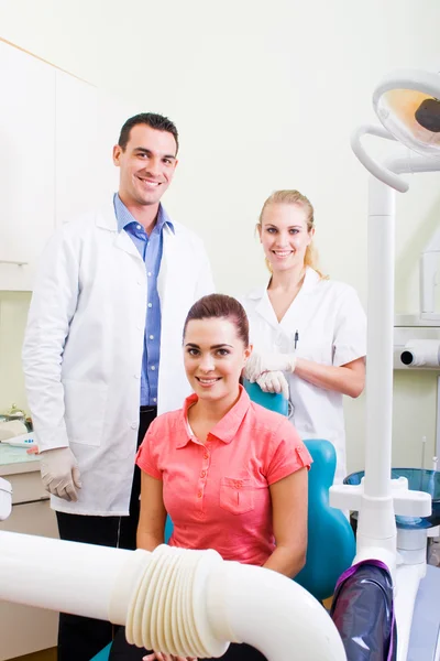 Dentista e auxiliar com paciente no consultório — Fotografia de Stock