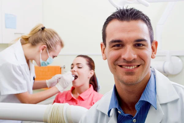 Vänliga manliga tandläkare i sin praktik — Stockfoto