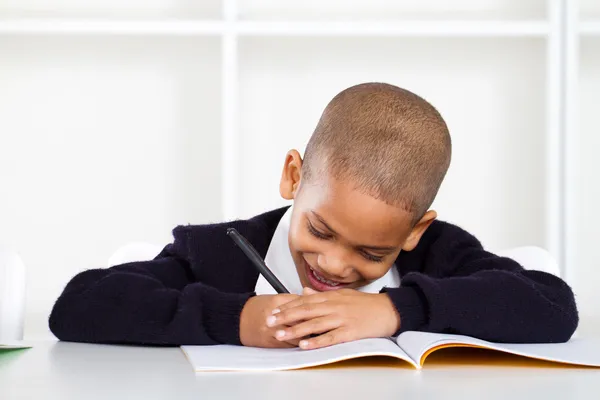 Bonito primário estudante escrever lição de casa — Fotografia de Stock
