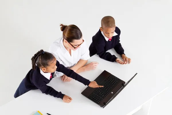 Primaire leraar en studenten met behulp van laptop — Stockfoto