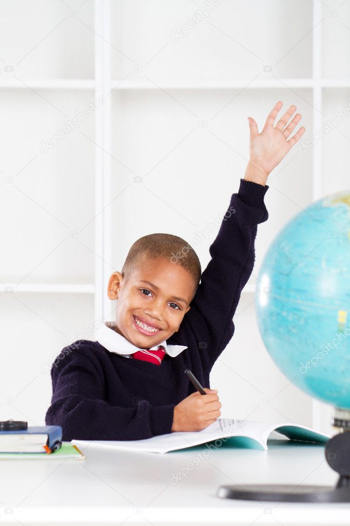 First grade student raising his hand in classroom