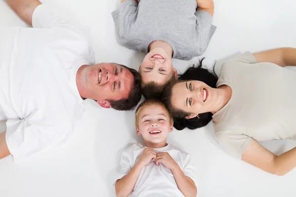 Liggend op de vloer en gelukkige familie — Stockfoto