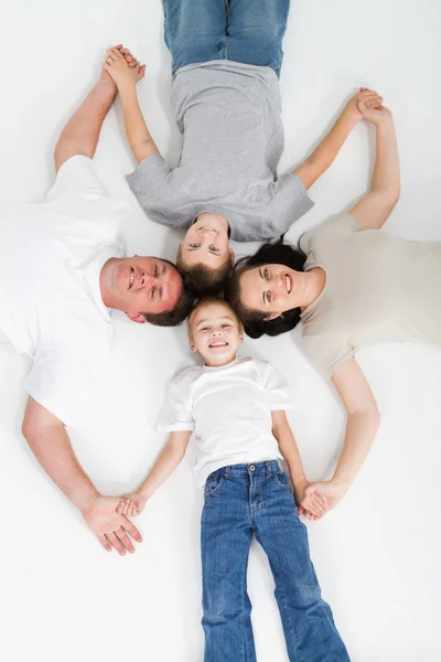 Šťastná rodina, ležící na podlaze — Stock fotografie
