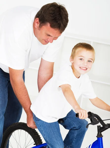 Father teaching son how to ride a bicycle — Stock Photo, Image