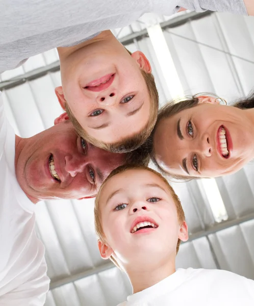Счастливая семья из четырех человек смотрит вниз — стоковое фото