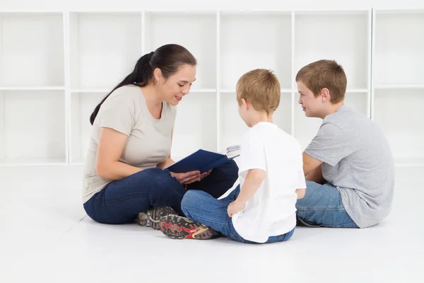 Мать читает книги своим детям — стоковое фото