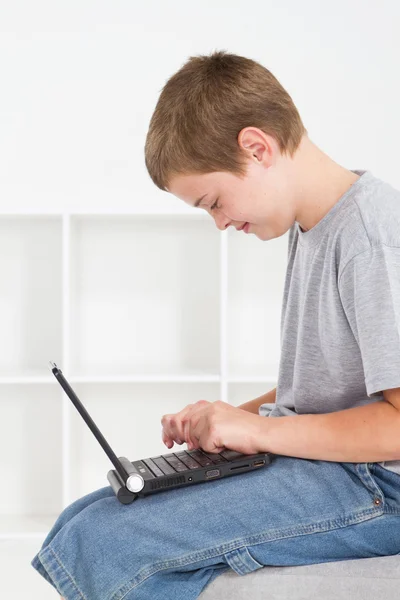 Teen boy using laptop computer — Stok fotoğraf