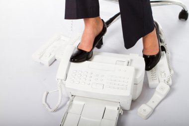 Stressed businesswoman stepping on fax and telephone clipart