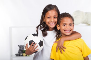 Brother and sister holding a soccer ball