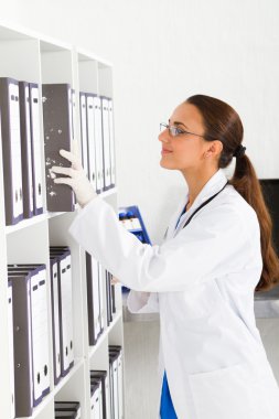 Medical intern searching for patient's records clipart