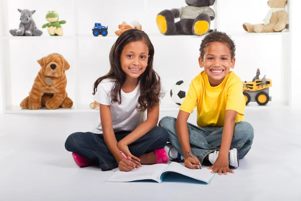 Brother and sister drawing on book — Stock Photo, Image