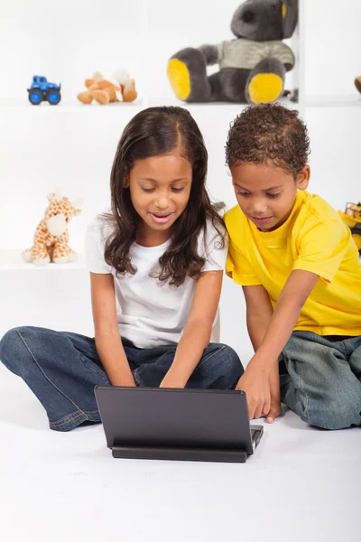 Брат и сестра играют на ноутбуке — стоковое фото