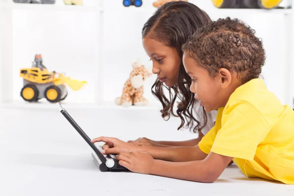 พี่ชายและน้องสาวชาวแอฟริกันอเมริกันเล่นคอมพิวเตอร์แล็ปท็อป — ภาพถ่ายสต็อก
