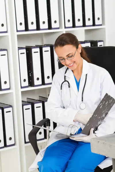 Молода медсестра переглядає файли в офісі — стокове фото