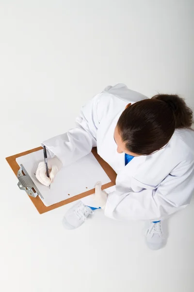 Medical nurse writing on clipboard — Stock Photo, Image