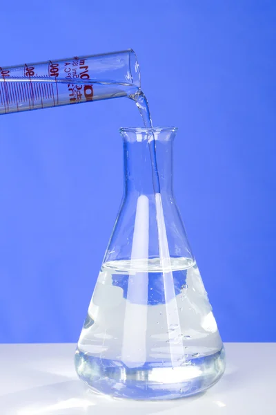 Tubo de ensaio que despeja líquido no frasco — Fotografia de Stock
