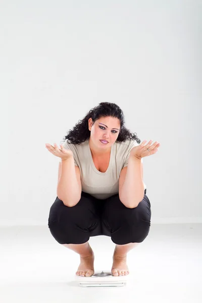 Женщина с избыточным весом на весах чувствует себя безнадежной — стоковое фото