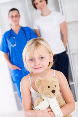 Little girl and mother in doctor's office clipart