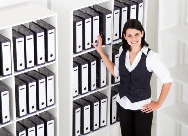 Businesswoman standing next to office files clipart