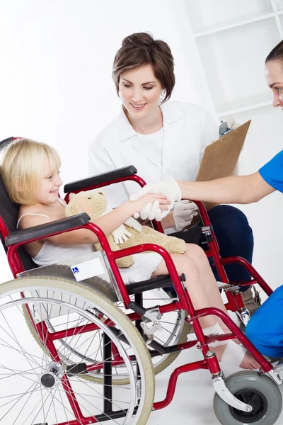 Doctor, enfermera estrechar las manos con niña pequeña paciente —  Fotos de Stock