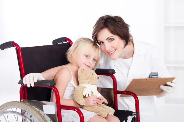 Заботливая медсестра и улыбающаяся маленькая девочка — стоковое фото