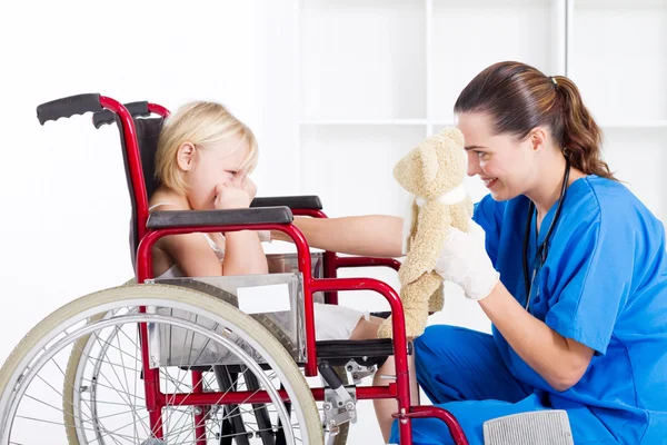 Enfermera animar triste niña paciente — Foto de Stock