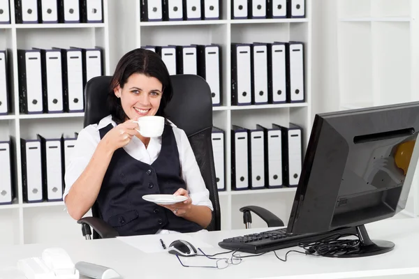 Affärskvinna som dricker kaffe i office — Stockfoto