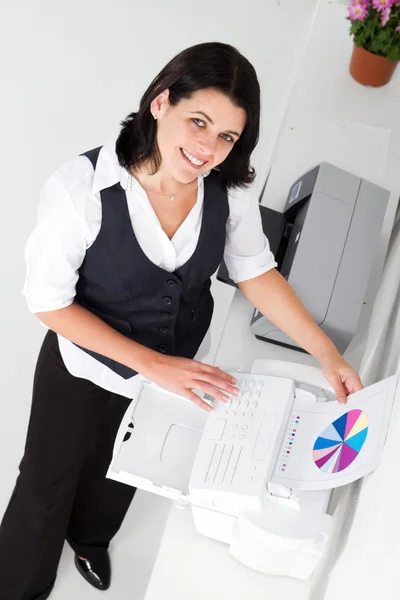 Businesswoman faxing document — Stock Photo, Image