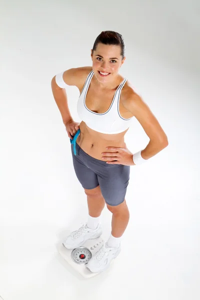 Молодая спортсменка, стоящая на весах — стоковое фото