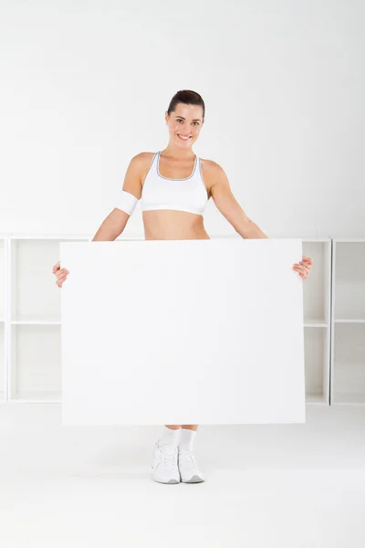 Junge Fitness-Frau hält eine weiße Tafel in der Hand — Stockfoto