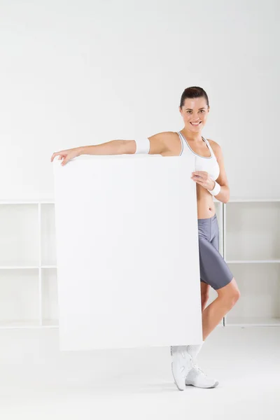 Mulher fitness segurando uma placa branca — Fotografia de Stock