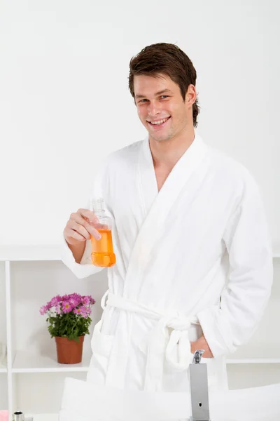 Young man in bathroom with mouth wash bottle — Stock Photo, Image