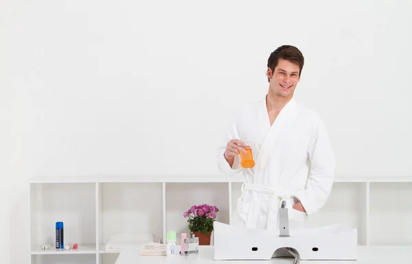 Молодой человек в ванной комнате с бутылкой для полоскания рта — стоковое фото
