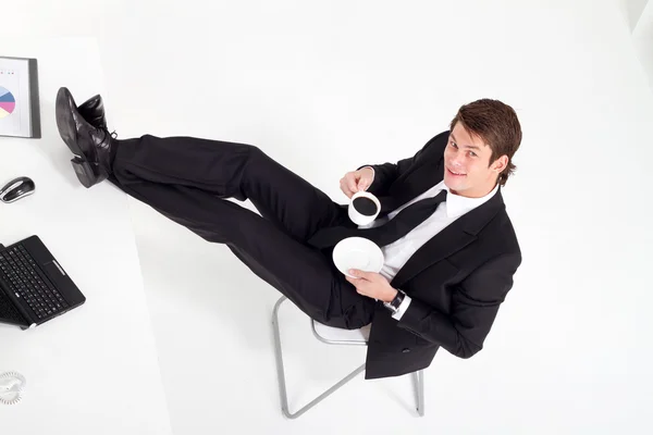 Νέος επιχειρηματίας που πίνει καφέ στο γραφείο — Φωτογραφία Αρχείου
