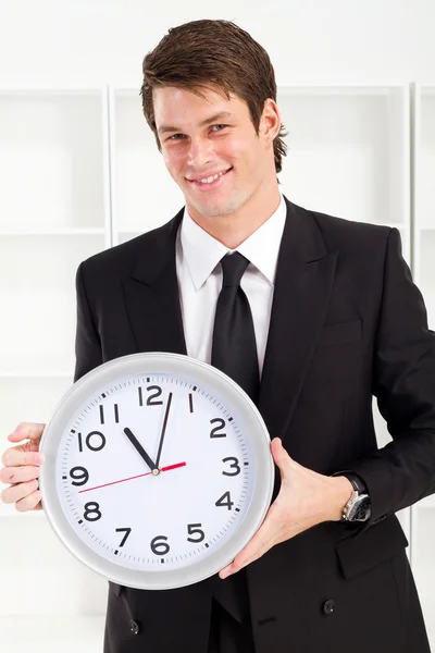 Joven empresario con un reloj en la oficina — Foto de Stock