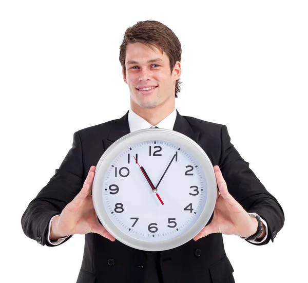 Young businessman holding clock over white — Stock Photo, Image