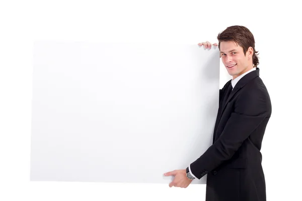 Jovem empresário segurando um quadro branco — Fotografia de Stock