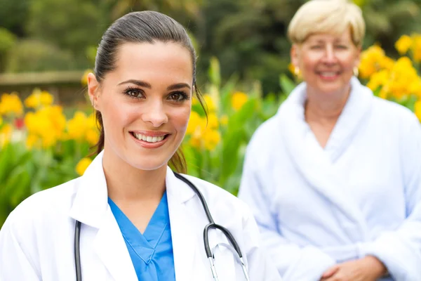 Friendly doctor and senior patient outdoors — Stock Photo, Image