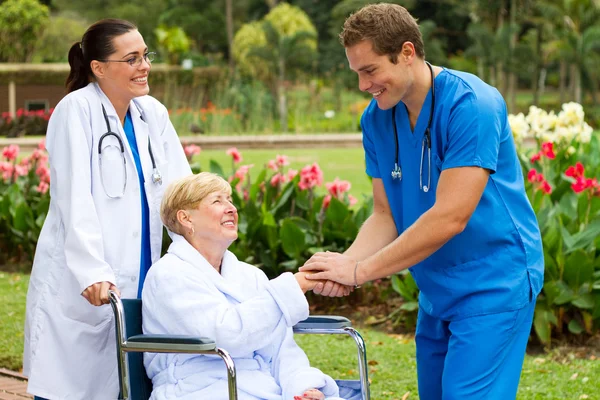 Дружелюбный доктор приветствует выздоравливающего пожилого пациента — стоковое фото