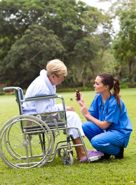 Női nővér elmagyarázzák, hogyan kell a gyógyszert felnőtt beteg — Stock Fotó